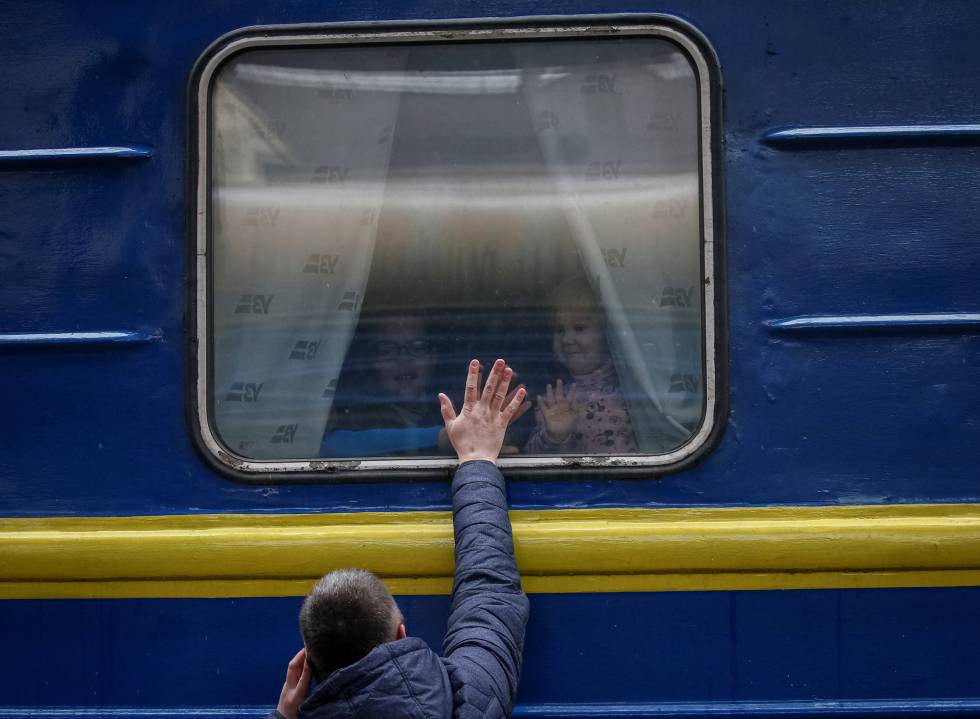 Un hombre se despide de varios niños, en la estación de Kiev, la capital de Ucrania, este jueves.