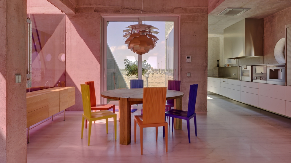 La sobria cocina Bulthaup B3 contrasta con el colorido del comedor, donde tienen cabida las sillas Jenette (Edra), la lámpara PH Artichoke de Poul Henningsen para Louis Poulsen y la mesa de Philipp Mainzer para E15.