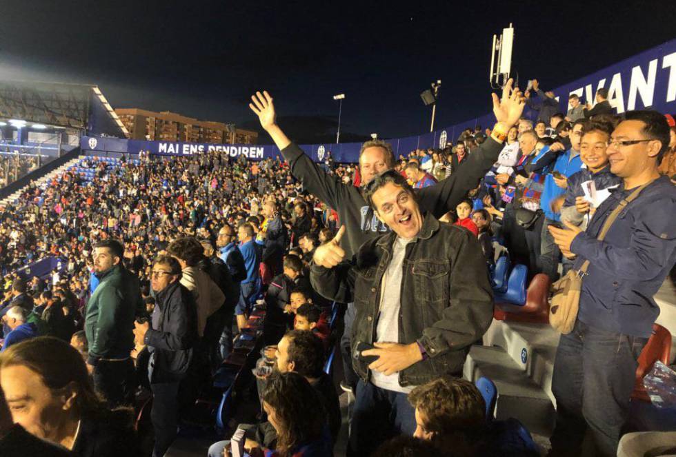 Graham Hunt es un liverpuliano forofo del Levante. Se mudó a España hace 25 años y se ha enamorado de los equipos de las ciudades en las que ha vivido. Se instaló en Asturias durante cinco años y allí se aficionó al fútbol español a través del Sporting. Tiempo después se trasladó a La Pobla, en Valencia, donde se ha hecho del Levante. Los encuentros los ve con sus hijos, Dani y Anita, de 14 y 12 años, y cuatro o cinco familias más. Aún conserva la pasión por el equipo de su ciudad, el Liverpool, una afición que se preocupa por transmitir a su prole. Hace unas semanas llevó por primera vez a su hijo Dani a Anfield, el campo del Liverpool. "Él es más forofo que Anita", apostilla Graham “Y se marchó feliz”, termina. El equipo inglés venció 4-0 al Estrella Roja de Belgrado.  En la foto: Graham en el centro durante un partido en el estadio Ciutat de València.
