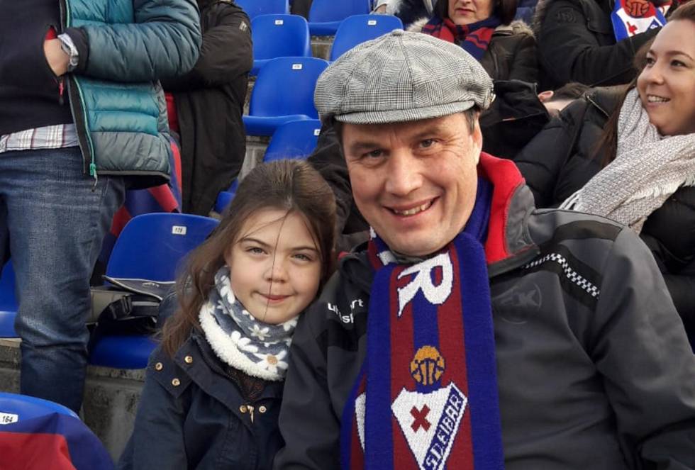 Tras vivir en Estados Unidos, Italia y México, el alemán Matthias Guterl, de 51 años, desembarcó, en 2011, en San Sebastián para trabajar en la industria metalúrgica. El fútbol vasco en seguida captó su atención. Especialmente el Eibar, cuando subió de Segunda B a LaLiga 1|2|3 en 2013. "El club despertó mi curiosidad, me sorprendía lo que estaba logrando un equipo local con un estadio pequeño", comenta. Al año siguiente, el Eibar subió a la máxima categoría por primera vez. Matthias, exjugador en su juventud y entrenador de equipos juveniles en Alemania, se contagió del sentimiento de alegría que embargó a la ciudad y convirtió a toda su familia en accionista. Una acción para cada uno, incluso para sus hijas mellizas, que ahora tienen doce años. A una le encanta ir con él a los partidos. “El fútbol en las gradas es distinto. En Alemania gritan más y aquí se canta más”.  En la foto: Matthias junto a su hija.