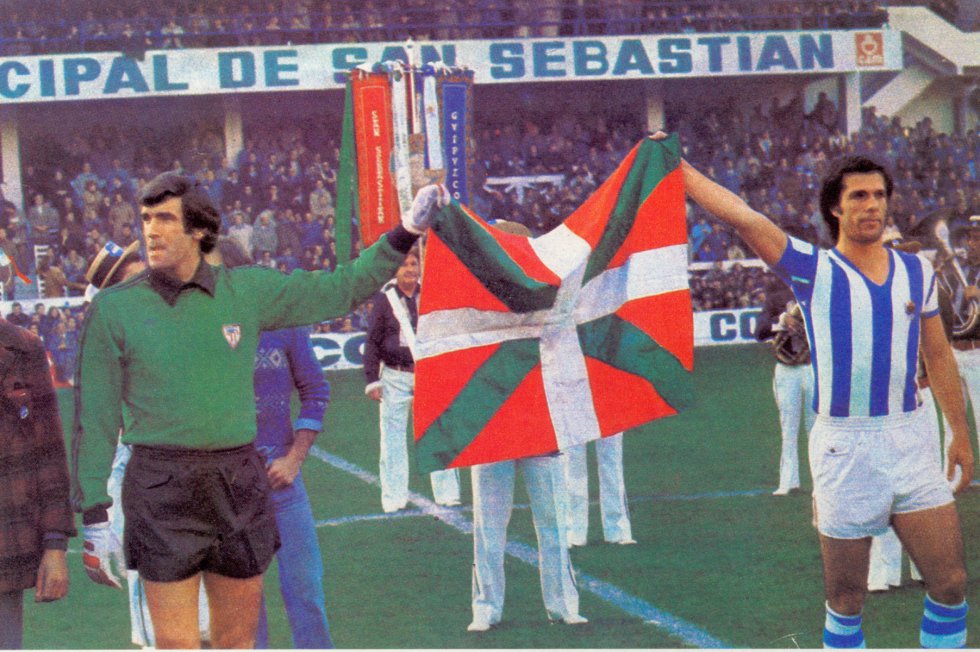 La mayor goleada de la Real al Athletic llegó en el conocido desde entonces como “derbi de la ikurriña”: 5-0. El 5 de diciembre de 1976 los capitanes del Athletic y la Real –Kortabarria e Iribar– salieron al campo sujetando una ikurriña que les había proporcionado otro jugador de la Real, Uranga, que no estaba convocado. La ikurriña no había sido legalizada todavía y fue recibida por un gran clamor de los aficionados. Pocas semanas después, el Gobierno autorizó su uso. La goleada presagiaba la llegada de la mejor generación de canteranos txuriurdines, con Kortabarria como avanzadilla.