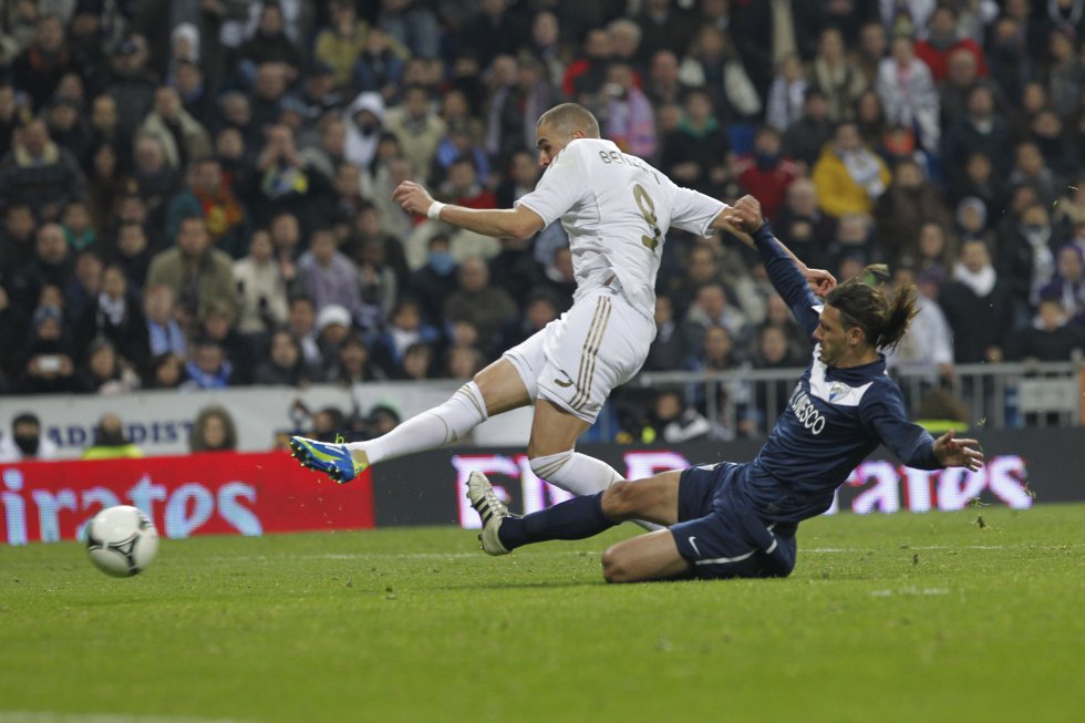 El central Martín Demichelis, canterano de River, llegó al Málaga desde el Bayern de Múnich en 2011 y se clasificó con el equipo para la Champions League en su primer año. Fue la mejor temporada liguera en la historia del club. Un año más tarde, estuvo a punto de alcanzar las semifinales de la competición europea en 2013 en una agónica eliminatoria contra el Borussia Dortmund. Pasó por el Atlético y por el Espanyol y volvió a Málaga para retirarse en 2017. En la imagen, el central trata de frenar la arrancada y el disparo de Karim Benzema.
