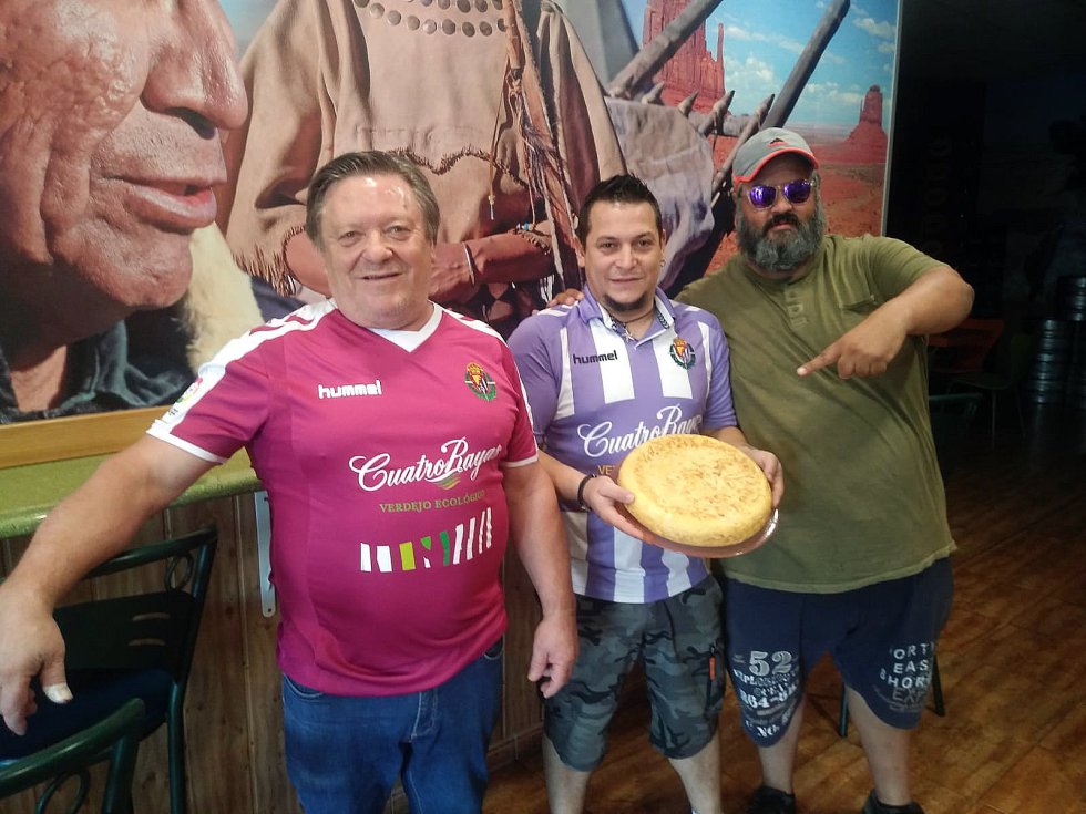  Fernando Carrión, de 61 años (izquierda), y David, su hijo, de 33 (centro), preparan en la cocina de su pequeña churrería de Valladolid una tortilla de patatas con 22 huevos que se ha convertido en un amuleto para el equipo de la ciudad. Ángel Martín Toribio, 'Angeloso' (39 años), uno de sus aficionados más conocidos, obsequiaba con una a la primera plantilla cada vez que ganaba un partido. La pasada temporada, antes del ascenso a LaLiga Santander, el entrenador Sergio González Soriano convirtió la costumbre en una cábala. “¡Queremos más tortilla!”, gritaban a Angeloso los jugadores blanquivioletas en los festejos del ascenso hace un par de meses. “La receta es del jefe”, confiesa David.     La Churrería es ahora un emblemático bar del Pucela, aunque quede a unos cuantos minutos del Estadio José Zorrilla. “La marca Valladolid se está expandiendo con mucha fuerza. Es una buena noticia para la ciudad, para los vecinos, para todos”, opina Carrión hijo. Esta buena noticia llamada fútbol aumenta el PIB de las provincias. Muchos negocios y muchas familias viven del fútbol directa o indirectamente. Para Enrique Moreno, director de Marca Global de LaLiga, el crecimiento del fútbol revierte en toda la sociedad. “Construir y trabajar por una marca global no está reñido con los sentimientos de la gente por su equipo de toda la vida o por el arraigo a los jugadores que ves y saludas por las calles. La globalización beneficia a todos”. Hasta un mito del fútbol brasileño y mundial como Ronaldo Nazario se ha fijado en el potencial del Real Valladolid. Desde hace unos días es su nuevo propietario. 