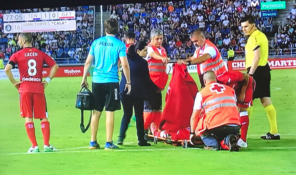 Ana de la Torre ve todos los partidos del Getafe. Sabe, al ver caer a un jugador, si solo se levantará magullado o si corren peligro sus isquiotibiales o el ligamento cruzado anterior. Deformación profesional. Ha sido la primera médica en saltar a un campo de LaLiga Santander y, ahora, la única doctora en un equipo de la élite de LaLiga (en la imagen, durante un partido). Se sumó a los azulones hace 12 temporadas ante la sorpresa de sus futuros 'pacientes'. “Les llamó la atención”, dice la especialista en Medicina del Deporte, de 45 años. Algo que no le ocurrió con judokas, atletas o ciclistas, “que no se plantean si el médico es hombre o mujer”. Vela, junto a otro compañero, por la salud de los deportistas del primer equipo del Geta y está presente tanto en los entrenamientos como en los partidos. “Siempre me gustó el deporte. Tratas con gente sana que desea recuperarse pronto, y hace todo lo posible”. Compagina la camiseta del Getafe con la vicepresidencia de la Asociación Española de Médicos de Equipos de Fútbol (AEMEF), que integra a 176 facultativos. En la clínica Cemtro, además, trabaja como experta en traumatología deportiva, esa disciplina donde la innovación hace milagros. Así que desde el banquillo, junto a cuatro fisioterapeutas, piensa en la manera más rápida de recuperar al jugador caído.