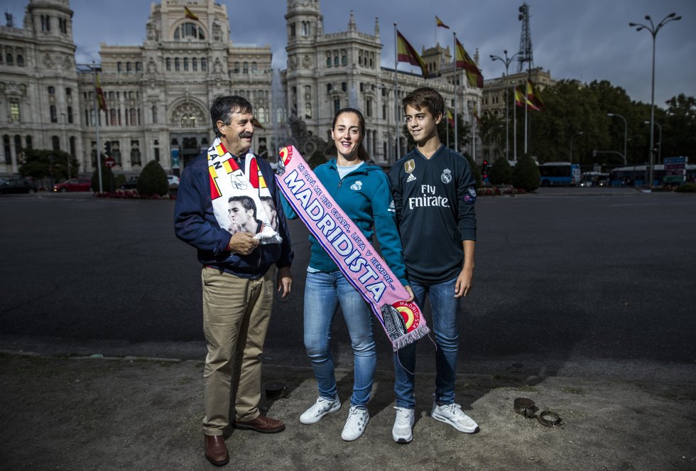 Natalia Mejías, madrileña de 37 años, se aficionó al Real Madrid cuando entraba en la adolescencia. En aquella época empezó a ver los partidos con su padre, Enrique Mejías, pastelero jubilado de 65 años. Con esa ocupación, no podían animar a otra formación que no fuera la merengue. En casa eran los únicos futboleros. "Mi padre el que más, y después yo", sentencia Natalia. Ella creció en el barrio de Prosperidad, muy cerca del Santiago Bernabéu, donde las tardes de partido se entretenía con un helado viendo a los futbolistas entrar en el campo. "Llegaban en sus coches y se bajaban a hablar con quien estuviera por allí", recuerda esta profesora, que trabaja como asesora pedagógica en una editorial. "Entonces eran más cercanos porque no había teléfonos móviles y no les pedían tantas fotos".   Natalia entró por primera vez en el campo con 13 años. Es la única de los tres hermanos que vive los colores con emoción y eso que su hermana pequeña lleva la pasión merengue en el nombre: se llama Cibeles. "A finales de los ochenta el Madrid empezó a celebrar las victorias en la fuente, así que se lo propuse a mi mujer y ella, que es muy moderna, aceptó", recuerda Enrique, que sazona la historia con una anécdota. "Cuando llegué al registro me dijeron: '¿Cibeles? Será La Cibeles, ¿no?'. 'Y dije: '¿A usted la bautizarían La Juana?", relata entre risas.   Desde que está jubilado, el abuelo se encarga de llevar a su nieto Sergio, de 14 años, a los partidos que juega cada sábado. Al joven no se le da mal, lo convocan, de centrocampista, para todos los partidos. A Sergio le gustaría ser jugador profesional. A Natalia, su madre, no tanto. "Sergio tiene que estudiar, eso es lo principal. Se ha dado cuenta de que no puede ser futbolista". Él, en realidad, es más optimista: "A ver, futbolista puedo ser, pero ganar el Balón de Oro lo veo más complicado".    En la foto: tres generaciones del Madrid: Enrique Mejías, el abuelo, Natalia Mejías, la hija y Sergio Calero, el nieto, en la Plaza de Cibeles.