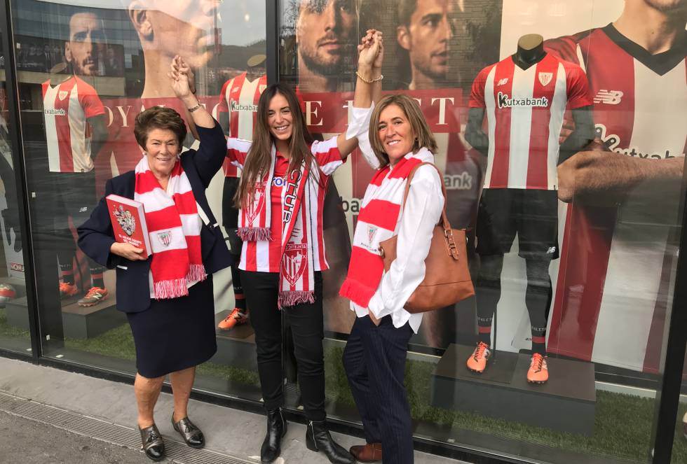 En casa de María Jesús Ondarra, bilbaína de 54 años, se vivía un ambiente muy futbolero. Los domingos, ella y su hermano pasaban la mañana en Lezama, donde entrenan todas las categorías y secciones del Athletic Club, y por las tardes iban al partido con sus padres, que nunca fallan a San Mamés. “Es forofa a tope", cuenta María Jesús de su madre, María Jesús Galarza, de 80 años.   María Jesús hija y su marido tampoco fallan a la cita con el Athletic, en un estadio en el que cada vez hay más mujeres. "Es bastante habitual, vienen solas, con amigos, en pandilla", apunta María Jesús. Su hija, Sandra Muro, de 24 años, es una de ellas. "Cuando no voy con mi abuela voy con mi cuadrilla", cuenta. Ella también ha sentido la pasión desde pequeña. Su primer regalo de cumpleaños fue la equipación del Athletic y comparte la afición con sus amigas, con las que ha recorrido España para animar al club. "Deseamos que el partido coincida con un puente para viajar, ver el partido y hacer turismo".   Ahora, que vive en Madrid, echa de menos compartir esos momentos con su familia, especialmente con su 'amama', su abuela. "Ir a San Mamés con ella es un planazo: verla disfrutar, incluso pasarlo mal a veces". Su mayor deseo, por encima de cualquier otro, asegura, es ganar LaLiga Santander para poder ver, con su madre y con su abuela, la gabarra surcando la ría con todos los jugadores a bordo.   En la foto: de derecha a izquierda, nieta, Sandra Muro; hija, María Jesús Ondarra y abuela, María Jesús Galarza, que sujeta orgullosa el 'El mejor equipo del mundo, un libro ilustrado por Tomás Ondarra, su hijo, con 108 anécdotas sobre el club rojiblanco.