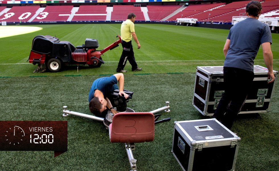 Durante todo el viernes coincidirán sobre el césped los encargados de su cuidado y quienes montan cámaras y micrófonos. En la imagen, mientras el jardinero apuntala el drenaje de la zona de la línea de banda, dos técnicos colocan el soporte rotatorio sobre el que irá la cámara número siete (de 27), con una óptica capaz de 86 aumentos para acercar la imagen a la que enfoca.