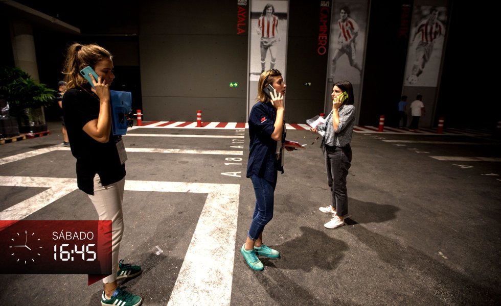 Faltan unos minutos para las cinco de la tarde del sábado y el ritmo de Katarzyna Humska, conocida por todos por el apócope de su nombre Kasia (en el centro) y el de su compañera en el área de producción de Mediapro Leticia Pasamontes (a la derecha) se vuelve frenético. En la foto, ambas atienden quehaceres al teléfono junto a una de las empleadas del Atlético en el Wanda Metropolitano. Están en la zona donde dos horas más tardes llegarán los autocares de los equipos. En la paredes, estampas de mitos rojiblancos como Pantic, Ayala o Caminero.