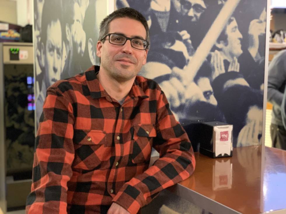 Ander Izagirre, en el bar Tribuna Norte en la plaza Campo de Atotxa con un póster de la afición de la Real Sociedad de fondo.