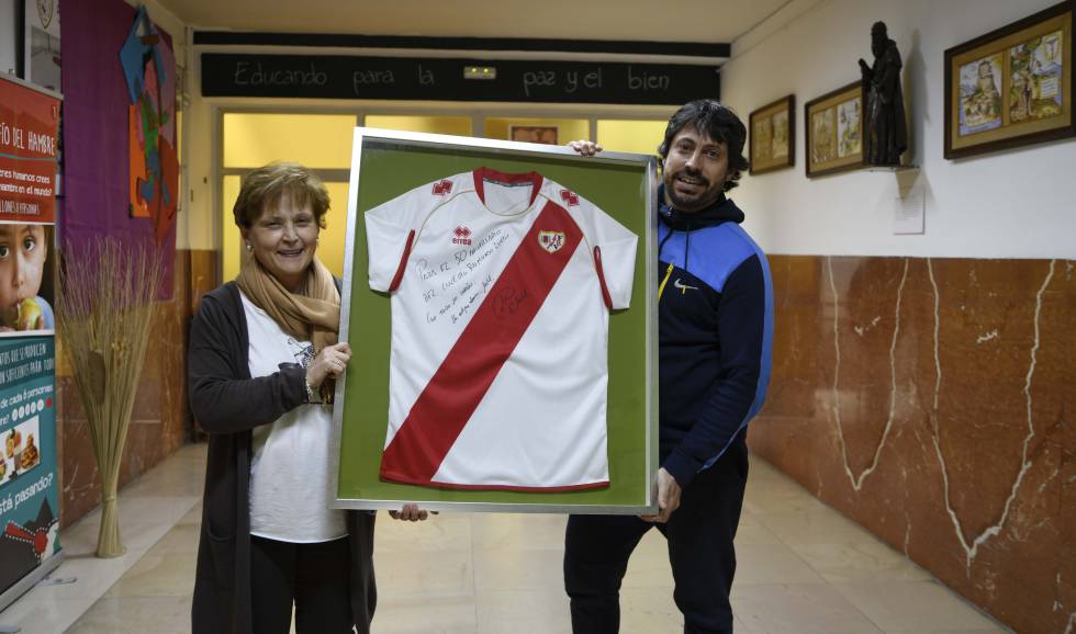 La maestra de Míchel y un antiguo compañero suyo, ahora también profesor del colegio, muestran su camiseta firmada.