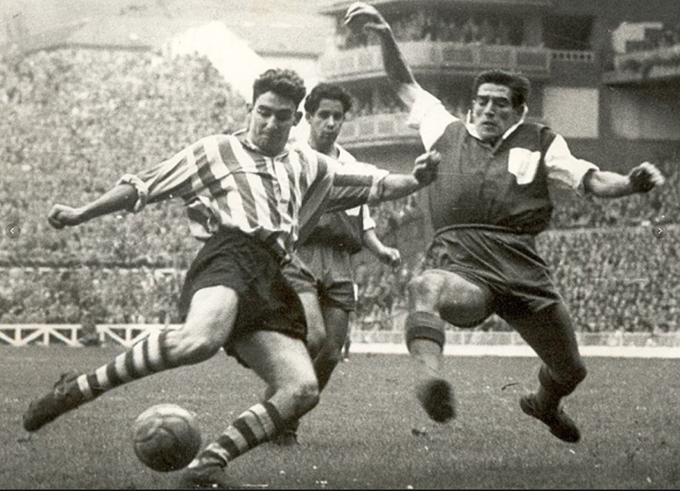 Los primeros balones estaban fabricados con cuero de vaca y tenían un cordaje del mismo material con el que se terminaban de cerrar y se escondía su válvula. No estaban hecho de polígonos, sino de tiras. Y su peso era similar al de los actuales, aunque multiplicaba su tamaño si se mojaban. “Eran de un color marrón oscuro. Solo se empezó a jugar con balones claros cuando arrancaron los partidos nocturnos”, desarrolla Alfredo Relaño. El primer gran cambio en los balones llegó a partir del Mundial de México 70. “Se generalizó el modelo del Telstar, el primer balón con paneles pentagonales y hexagonales. Y era blanco y negro, lo cual lo hacía fácilmente identificable en televisión”. En la competición española, por ejemplo, se utilizaba el Adidas Inter. En la foto, José Luis Artetxe chuta ante un defensa del Atlético en San Mamés en un partido de la temporada 195455.