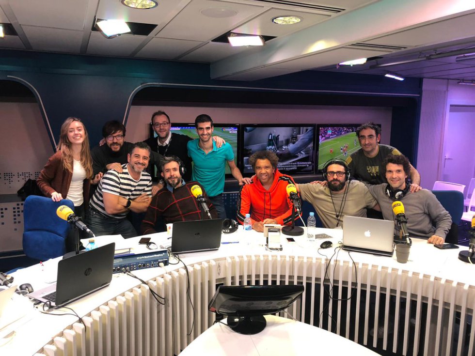 ‘Carrusel Deportivo’, dirigido por Dani Garrido (en la foto, sentado a la izquierda, junto a parte de su equipo y comentaristas), tiene hoy más de millón y medio de oyentes cada sábado y cada domingo. Los horarios han variado el concepto del ‘Carrusel’ hasta transformarlo en un programa que ocupa buena parte de la parrilla del fin de semana. Y mantiene la esencia del programa ideado por Bobby Deglané y Vicente Marco. “El objetivo sigue siendo el mismo. Estar cerca del oyente, contarle lo que pasa en cada campo con emoción, que viva el fútbol y que se sienta parte de la familia”, comenta Garrido, con casi 20 años de experiencia en la radio deportiva. “Lo que han cambiado son las herramientas que tenemos ahora para estar con nuestro público. Las redes sociales hacen que se nos escuche más y sobre todo nos permite escuchar más a los oyentes. Contestamos a sus preguntas en directo, hacemos encuestas, debatimos con ellos como si fuesen un comentarista más. Ahora incluso nos pueden ver hacer el programa a través de Twitter, Facebook o nuestro canal de Youtube. El fútbol es del pueblo y en la radio esas posibilidades nos han permitido dejarlo todavía más claro”.