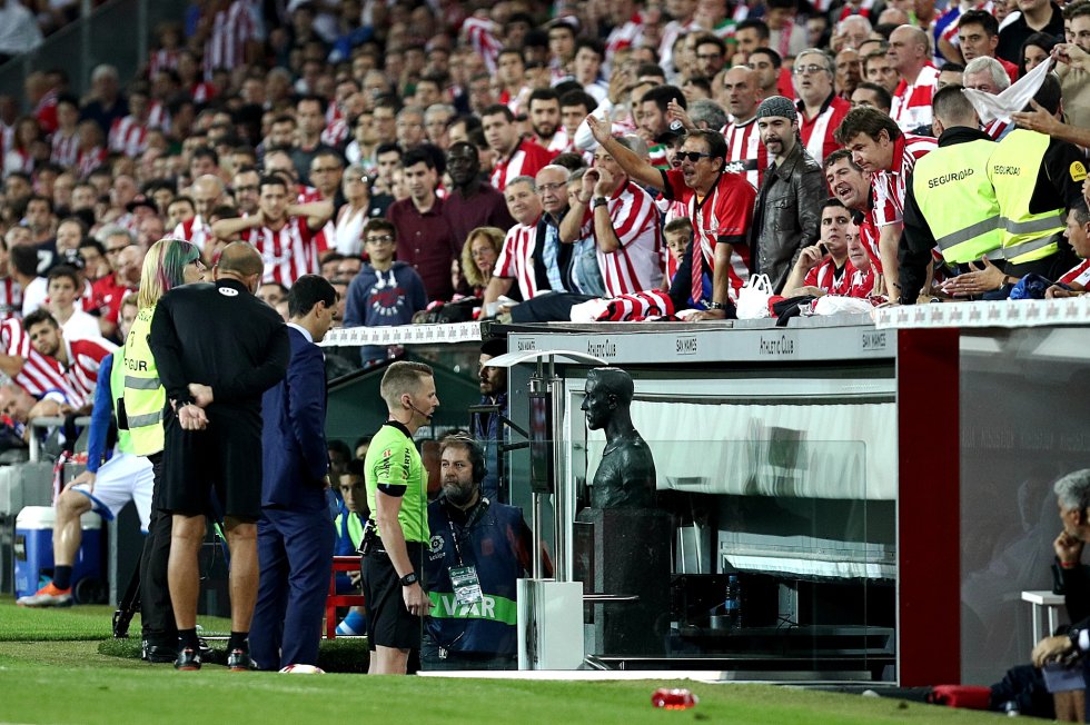 Iturralde González vivió la etapa de transición hacia la profesionalización total: “Cuando yo empecé a arbitrar en la élite cobraba unas 20.000 pesetas por partido, sin dietas ni transporte”, recuerda Iturralde, protésico dental de profesión. “Hoy los árbitros solo arbitran. Cobran unos 300.000 euros al año. Entrenan a diario. Cuidan su alimentación. Tienen médico y preparador físico. Se reúnen cada 15 días para analizar sus actuaciones. Y ha llegado el VAR”. El videoarbitraje es la última revolución en la normativa del fútbol español. Antes lo fueron las sustituciones, que hasta los años 70 solo se podían hacer por lesión. O las tarjetas, que llegaron a España en la temporada 197071. Aunque no había tarjeta amarilla, sino blanca, como explica Alfredo Relaño: “Fue iniciativa del entonces secretario de la Federación, Andrés Ramírez. Temió que en la pantalla de nuestros viejos televisores en blanco y negro las amarillas se podían confundir con las rojas”. Las amarillas llegaron seis años después. En la foto, Hernández Hernández consulta la pantalla del VAR ante el busto de Pitxitxi en San Mamés, en el primer derbi vasco de esta temporada.