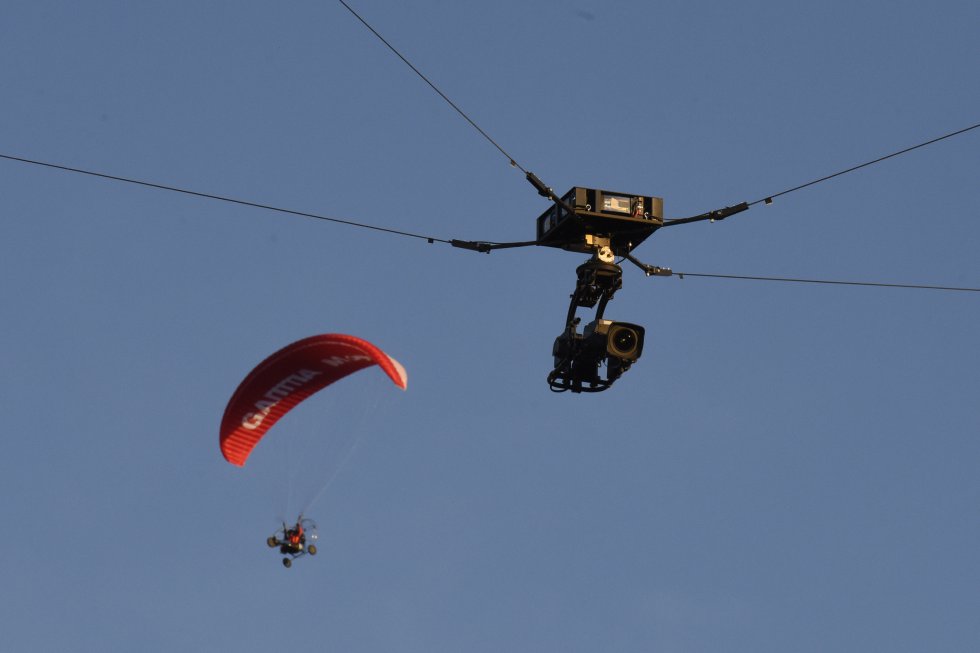 Las retransmisiones televisivas son hoy uno de los ejes de la industria futbolística. Hasta 32 cámaras pueden llegar a utilizarse en un partido. Se graba desde helicópteros, desde la línea de gol, con una Spidercam (cámara araña, en la foto) aérea sujeta por cables... En el último Clásico liguero ya había incorporada una tecnología que persigue el balón de manera automática y activa los micrófonos más cercanos para que se escuche con nitidez cada chut, cada grito de los jugadores y el ambiente del estadio. La televisión es la principal fuente de ingresos de los equipos.