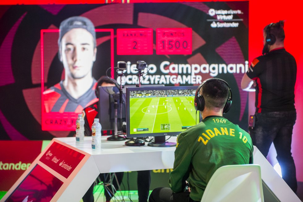 Hoy muchos aficionados no conciben el fútbol sin el videojuego de cada año. Una afición que llega a profesionalizarse en torneos como la Virtual LaLiga eSports Santander, donde 12.000 jugadores compiten por premios de hasta 40.000 euros. La industria del ocio electrónico ha creado un deporte que se practica sentado y con un mando y que da lugar a jugadas de campanillas, a veces incluso mejores que las del fútbol de carne y hueso. En la foto, Zidane 10, jugador profesional, durante una jornada del citado torneo. Por otro lado, la frase de que “todos llevamos un entrenador dentro” se comprueba en multitud de aplicaciones para el móvil que permiten crear equipos a partir de los jugadores de LaLiga y competir contra tus amigos durante toda la temporada en función de cómo se comportan los futbolistas de cada usuario en la vida real.