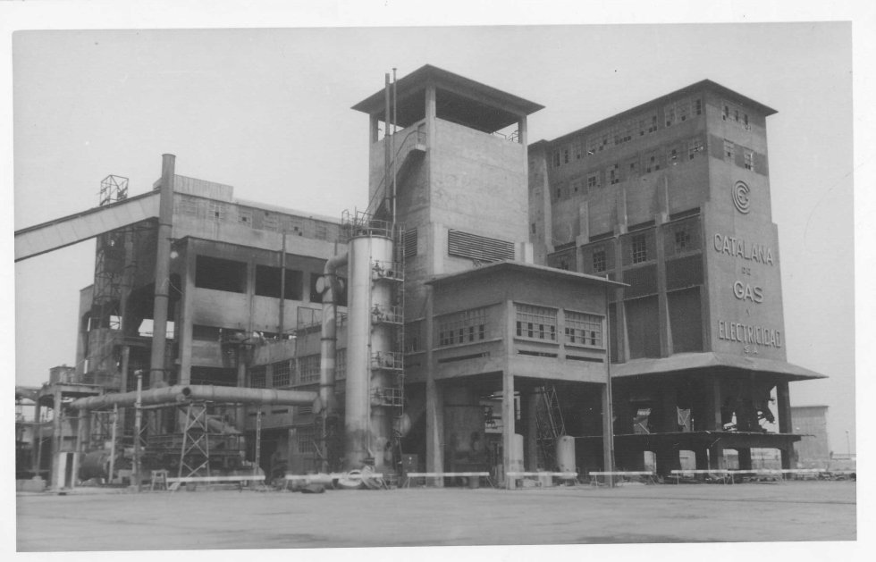   En la década de 1960 se implantan métodos más eficaces de producción y se cambia la materia prima: se pasa del carbón a las naftas, unos productos derivados del petróleo, y aumenta el uso del gas natural, el combustible extraído del subsuelo.    Edificio de los hornos Otto en la fábrica de gas de la Barceloneta. En el medio el gasógeno Otto nº 5 construido posteriormente. Fotografía de Ramon de Baños, 1965. Archivo Histórico de la Fundación Gas Natural Fenosa.  