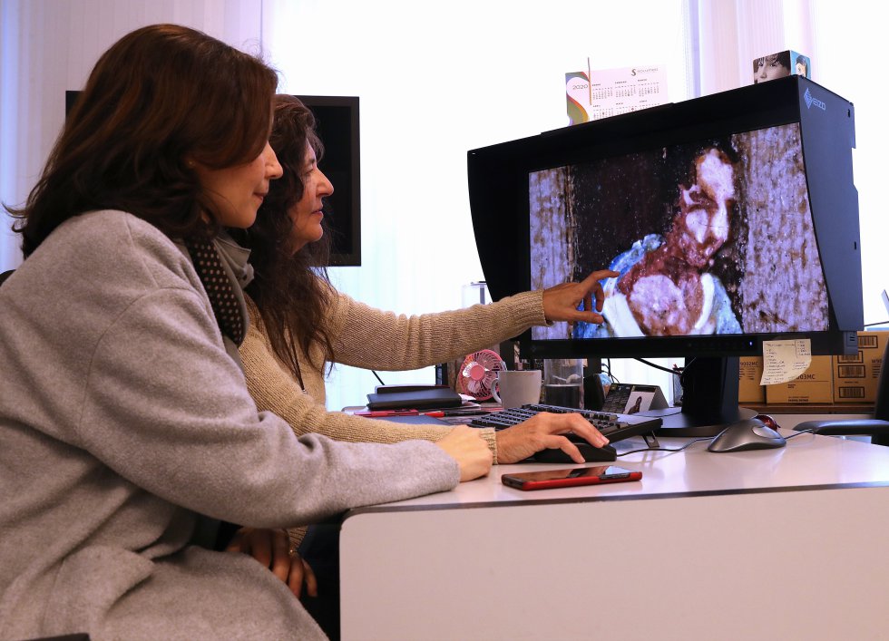 Dos miembros del equipo de restauración repasan los datos obtenidos durante el estudio técnico de la obra 'Vista de la plaza de San Marcos en Venecia', de Canaletto.