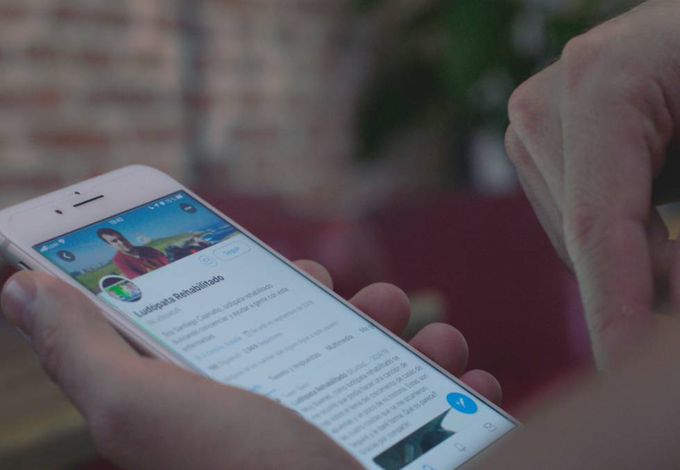 Ludópata rehabilitado, la cuenta de Twitter de Santiago Caamaño, en la pantalla de su móvil.